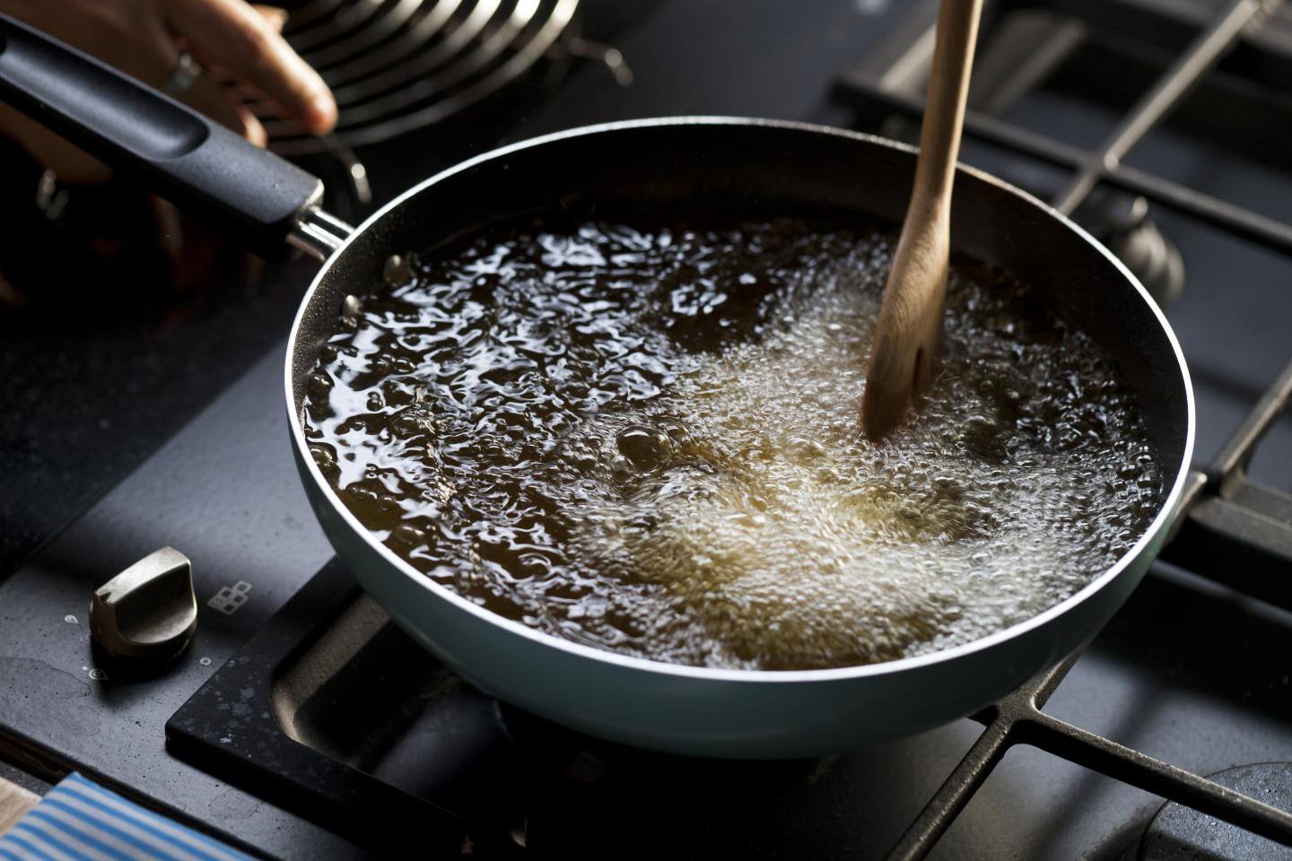 A frying pan sizzling with freshly caught, breaded fish